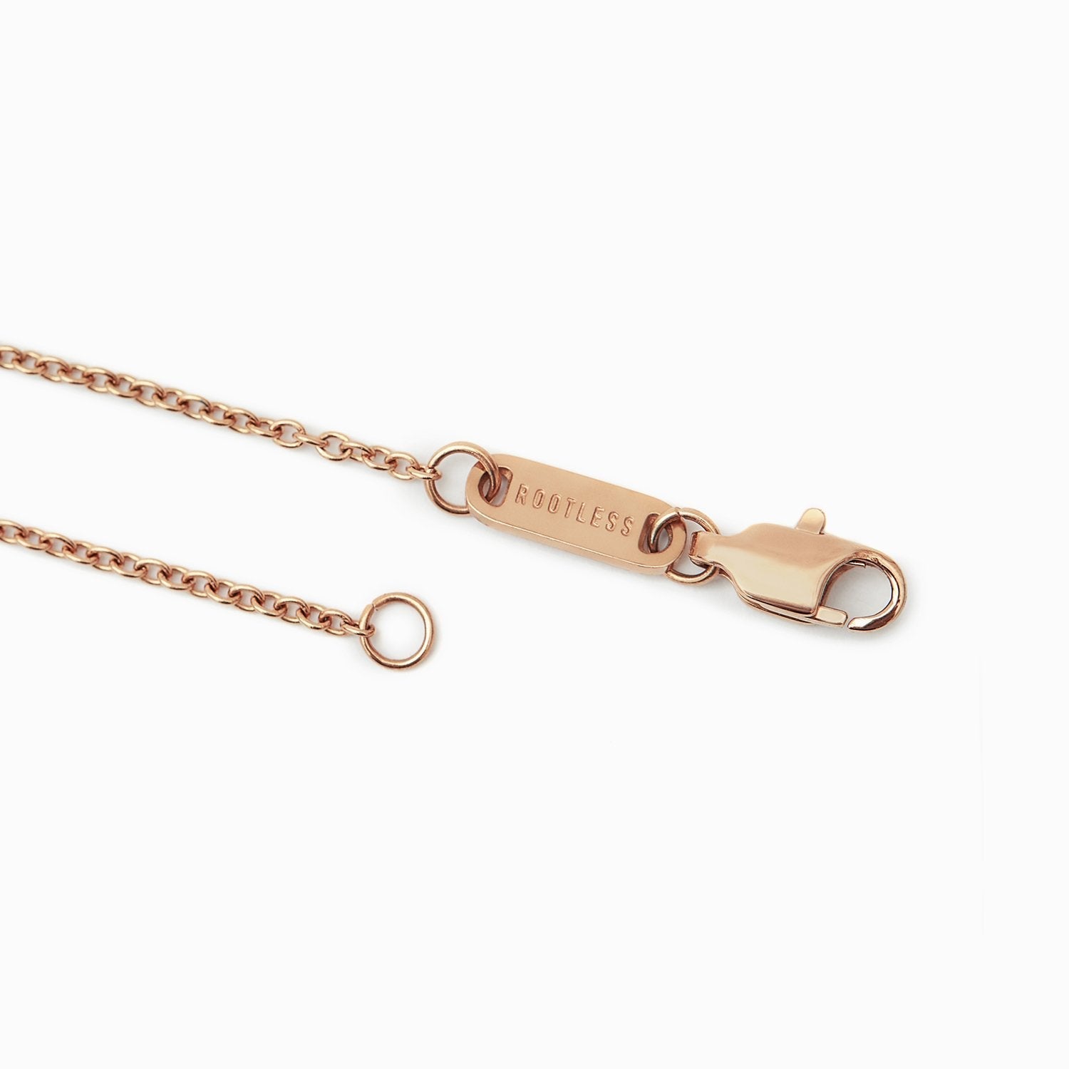 Detalle del mosquetón y la chapa ROOTLESS de la cadena Evora en oro rosa