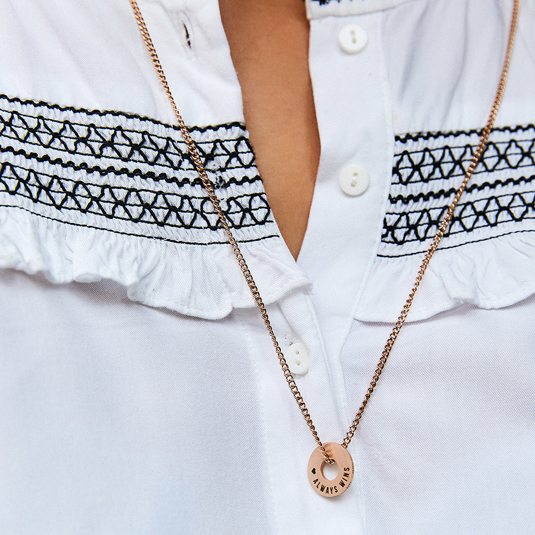 Anilla® en oro rosa y cadena Botany sobre una blusa blanca bordada