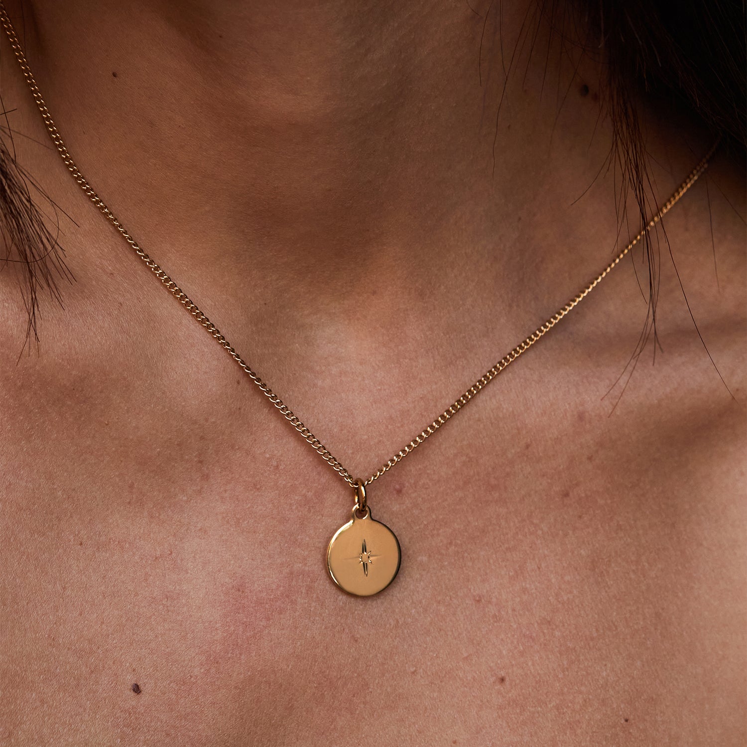 Collar Namib® dorado con colgante circular grabado sobre el escote