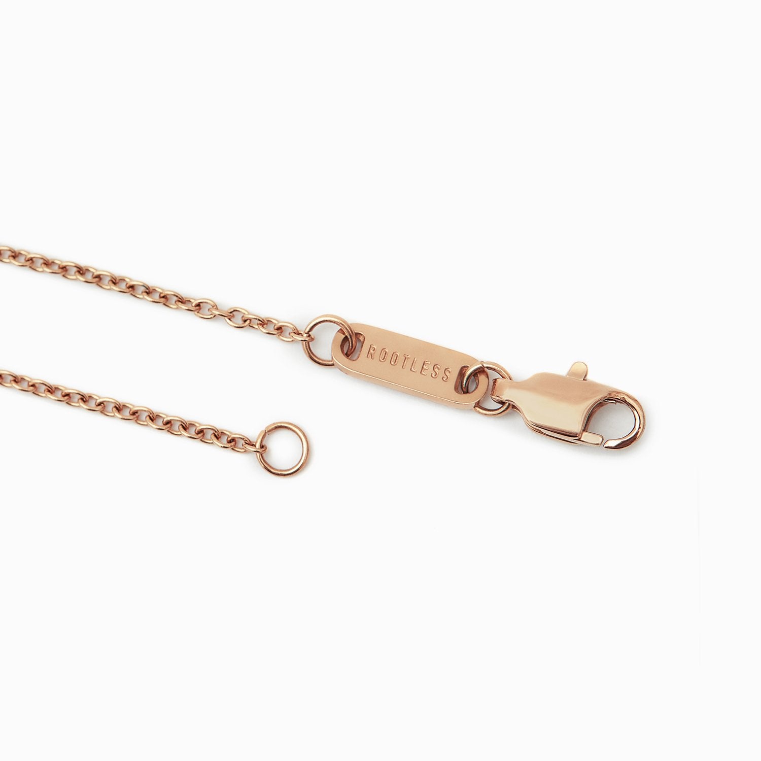 Detalle del mosquetón y la chapa ROOTLESS de la cadena Evora en oro rosa