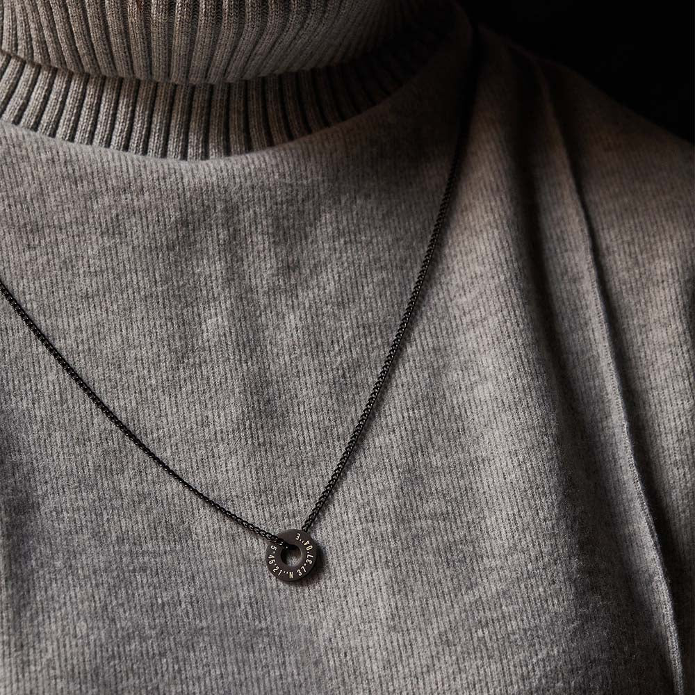 Collar Botany negro con Anilla® grabada sobre un jersey gris de cuello alto
