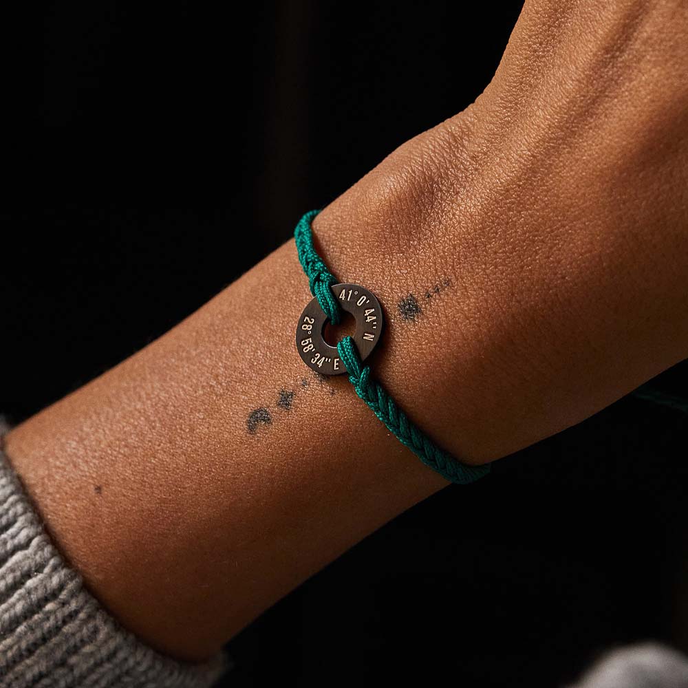 Pulsera MyWord® verde en la muñeca, con la anilla grabada visible