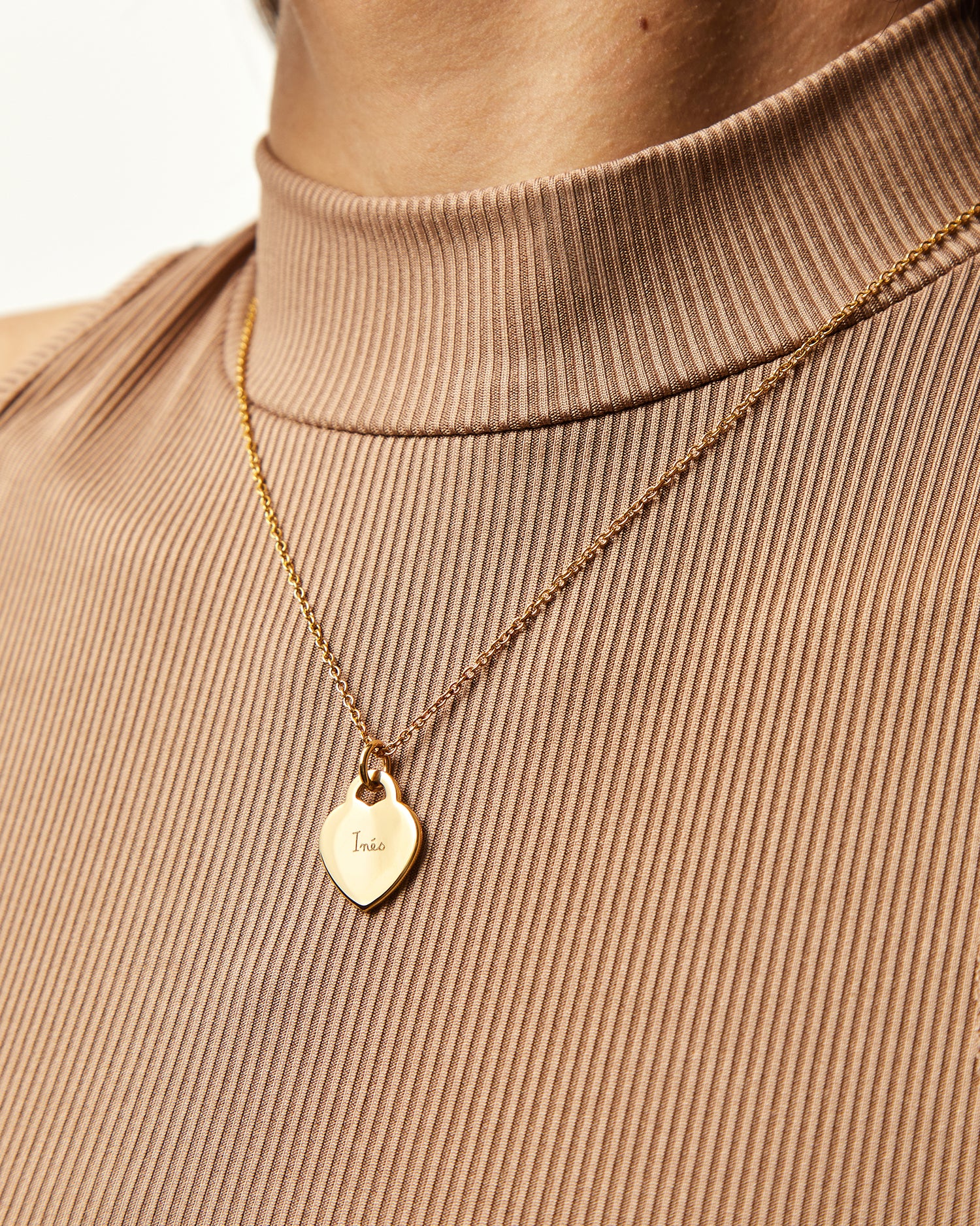 Collar Evora en oro rosa con Colgante Corazón® sobre un jersey beige