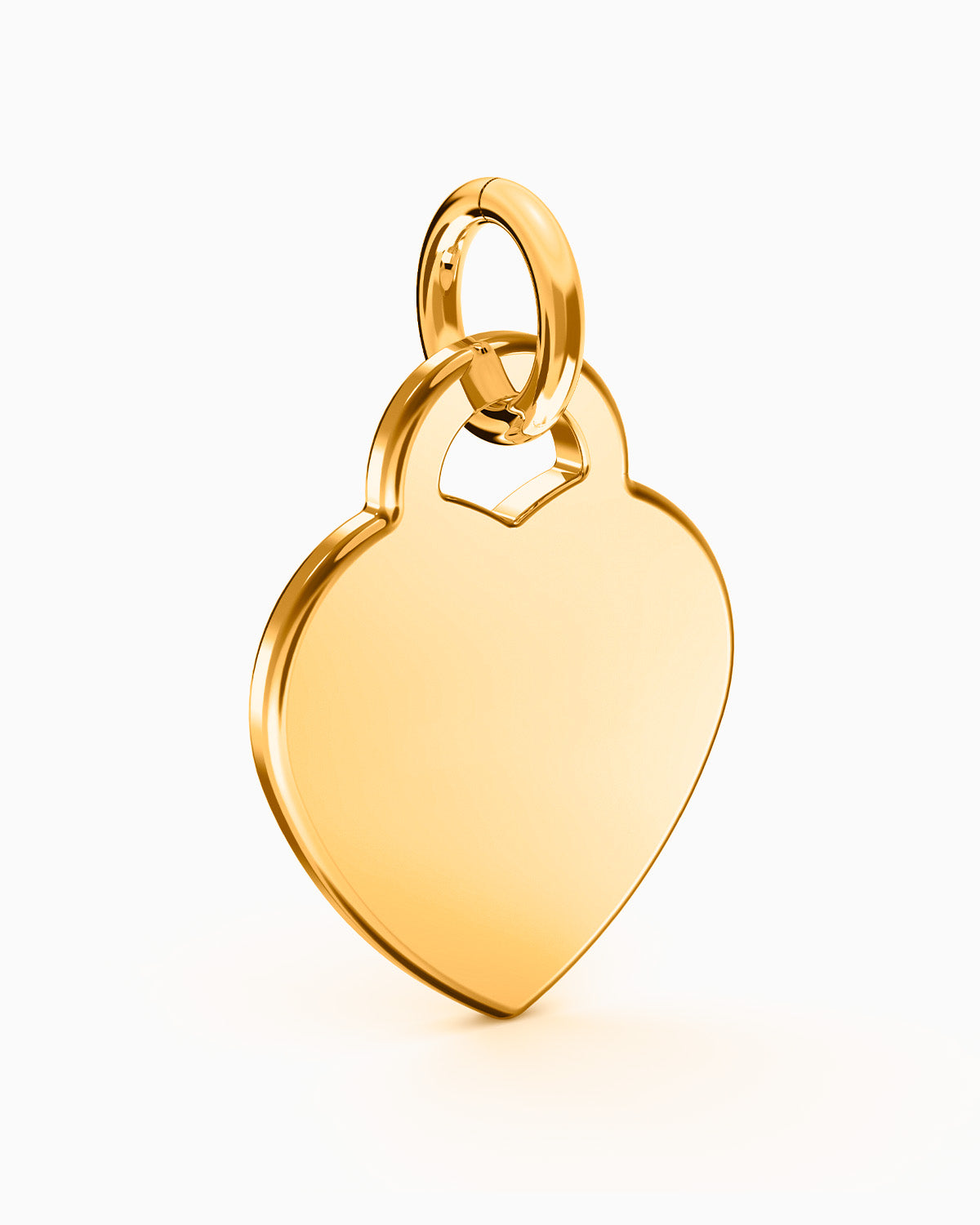 Colgante Corazón® dorado apoyado, mostrando su volumen y el canto