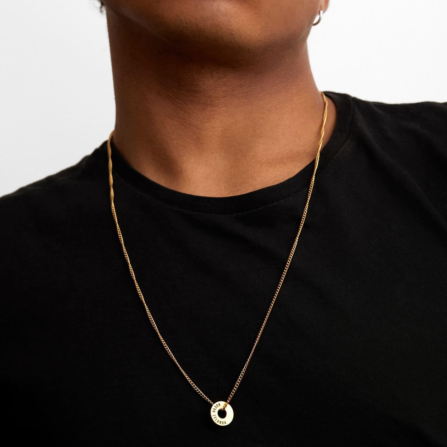 Anilla® dorada en cadena fina llevada sobre una camiseta negra