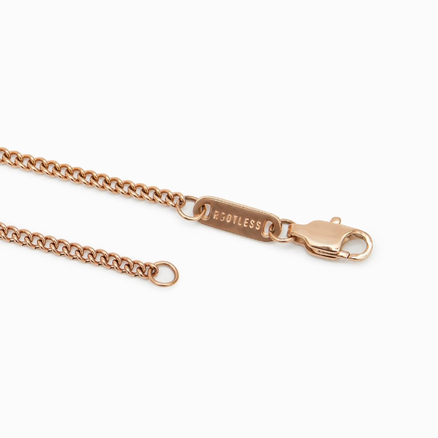Detalle del mosquetón y la chapa ROOTLESS del collar Botany en oro rosa
