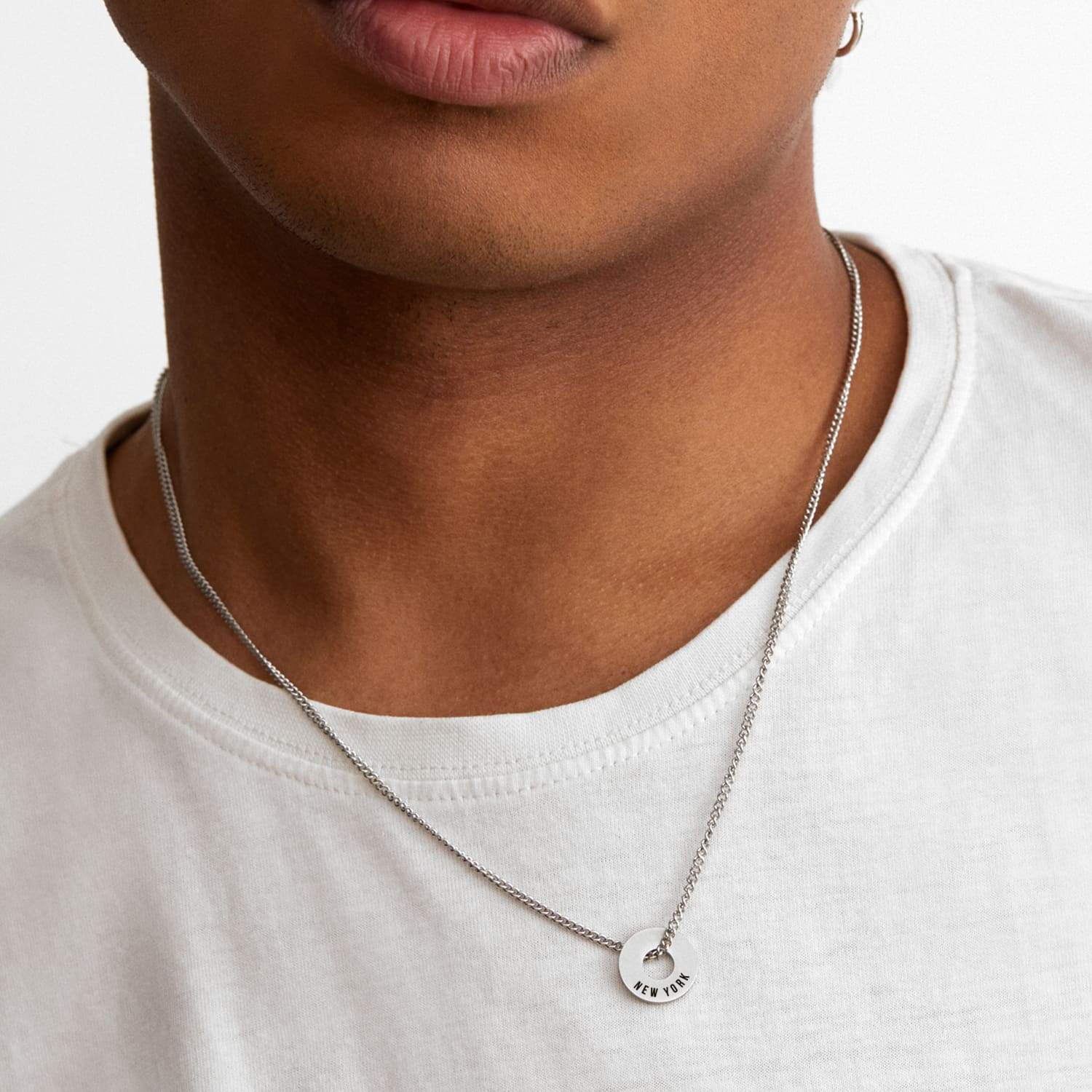 Collar Botany en acero con Anilla® grabada sobre una camiseta blanca