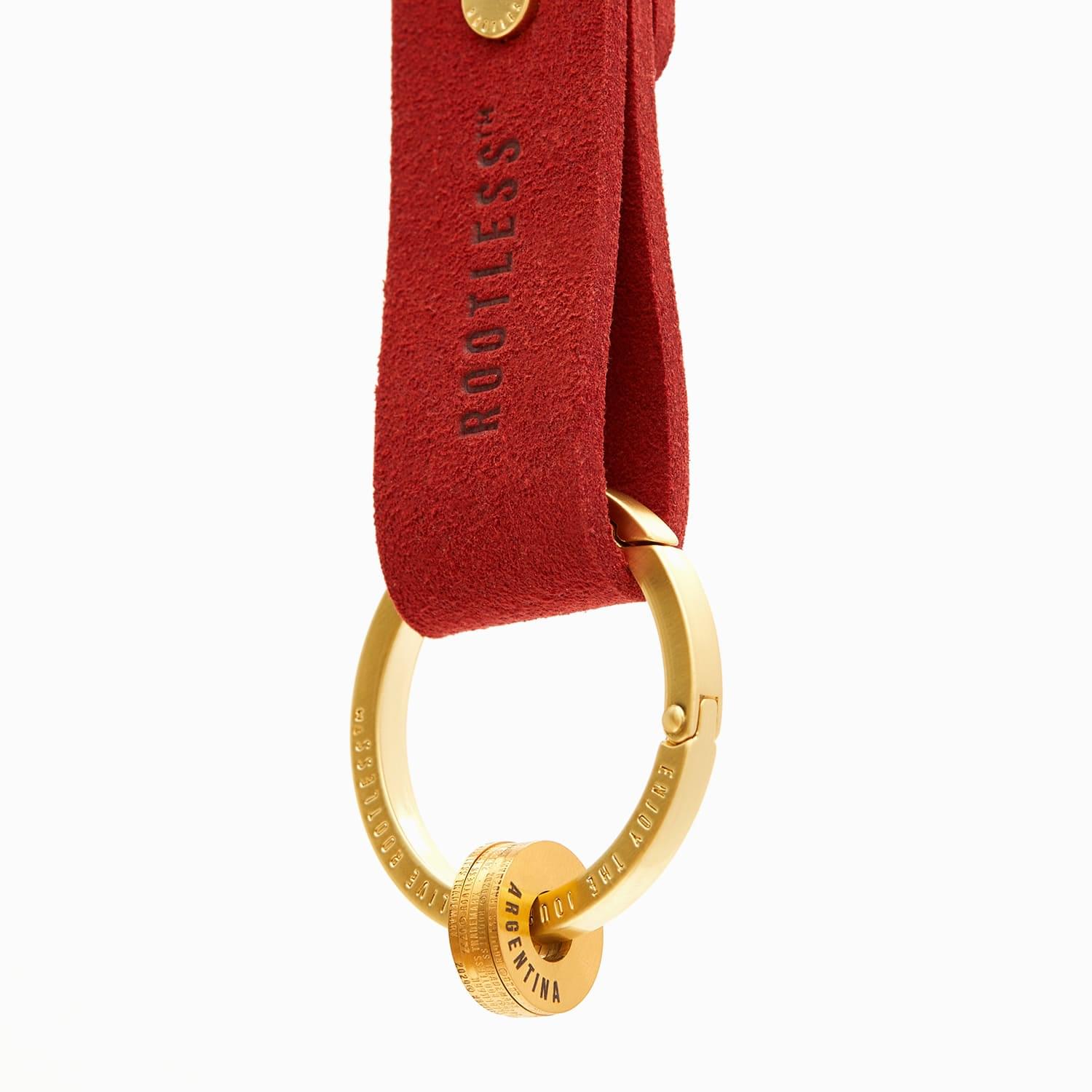 Anilla® dorada montada en un llavero de anilla con tira de ante roja ROOTLESS
