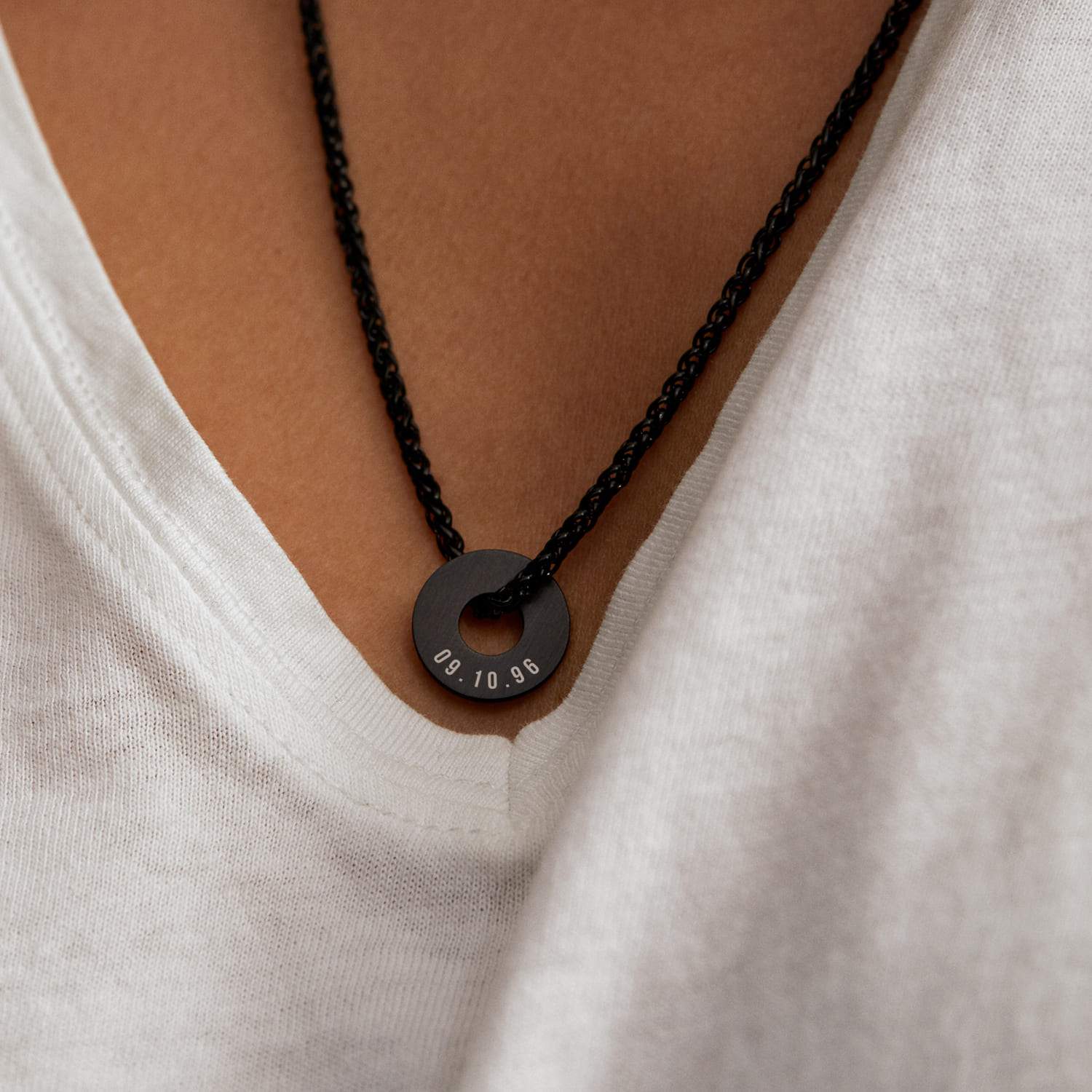 Anilla® negra con una fecha grabada sobre una camiseta blanca