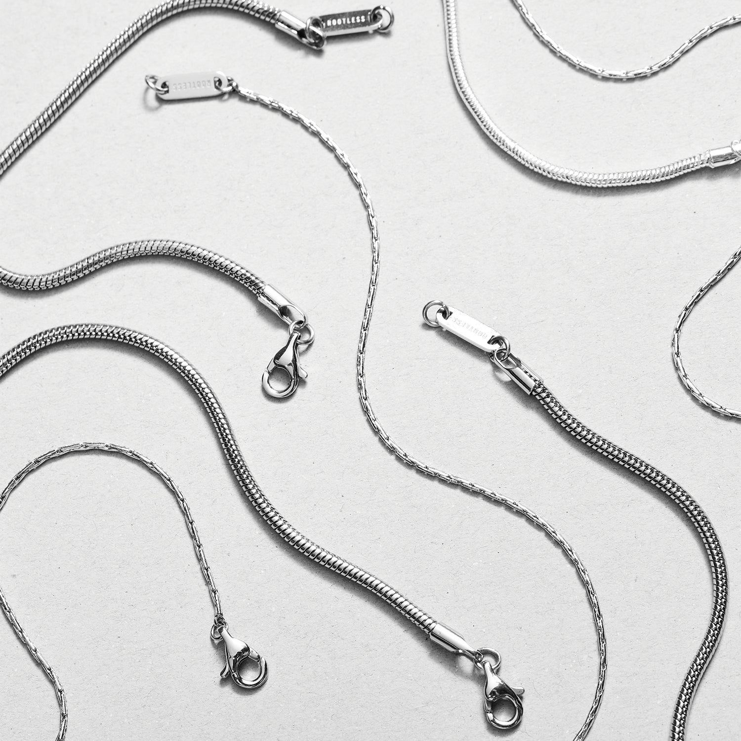 Varias cadenas Boa® en acero con sus mosquetones y chapas ROOTLESS