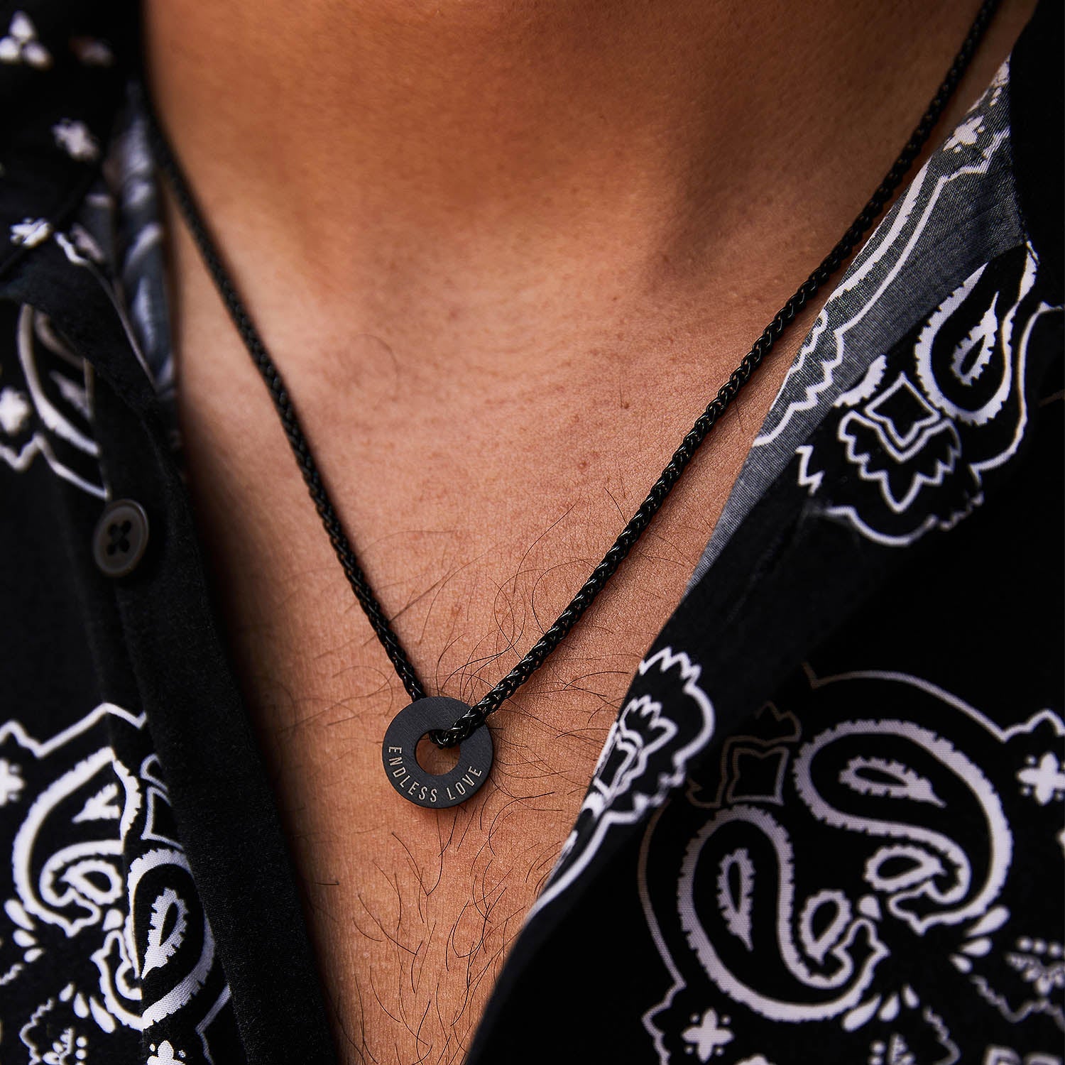 Collar Native negro con Anilla® grabada sobre una camisa de estampado bandana