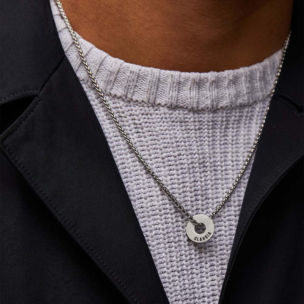 Anilla® grabada y cadena Native sobre un jersey de punto y camisa oscura