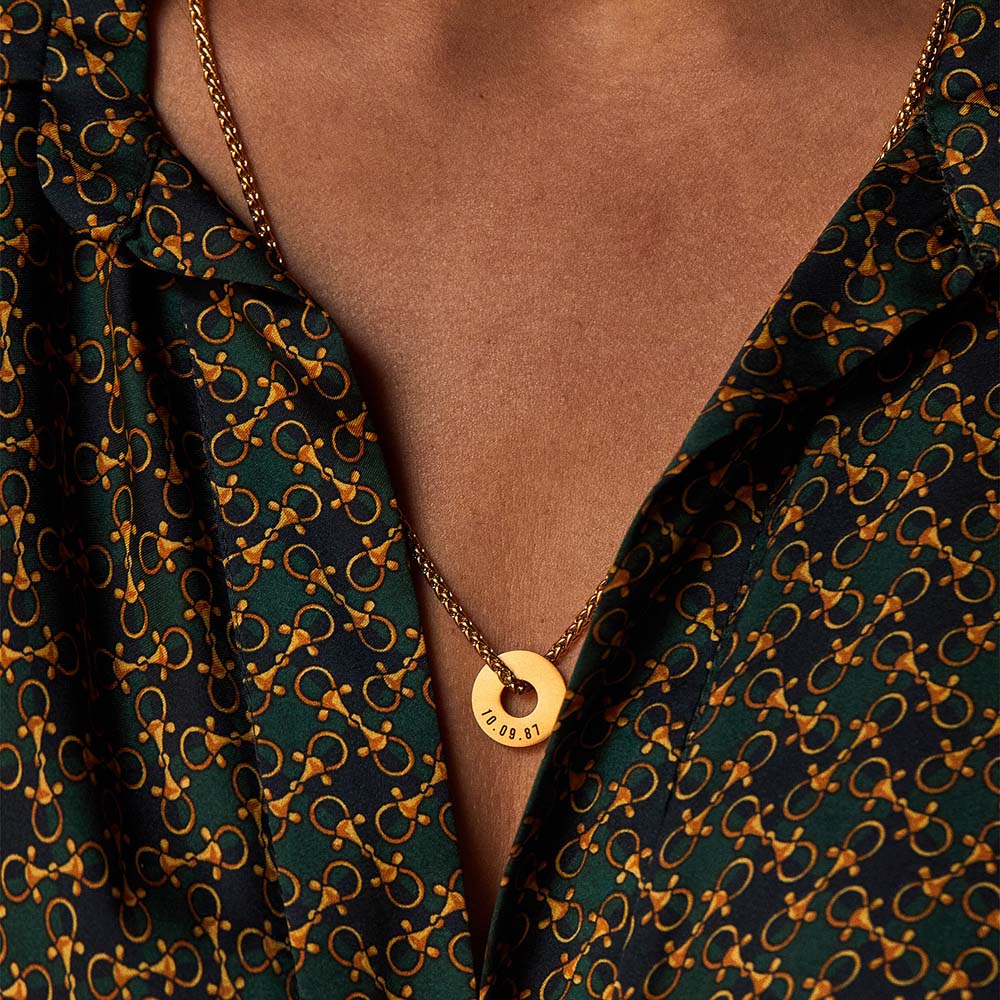 Collar Native dorado con Anilla® grabada sobre una camisa estampada