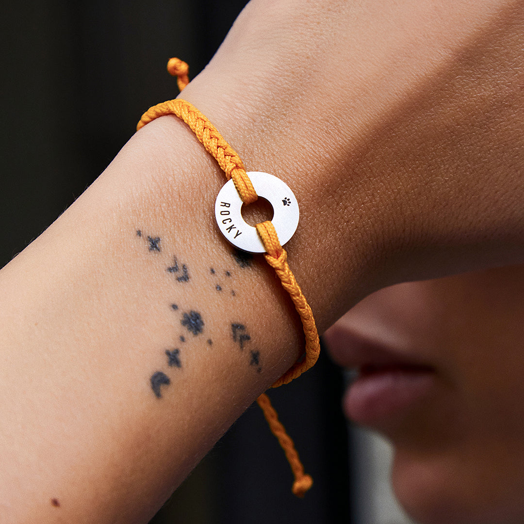 Pulsera MyWord® naranja con anilla en acero puesta en la muñeca