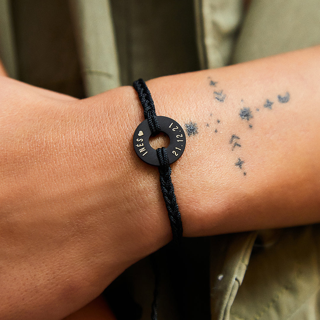 Pulsera MyWord® negra con la anilla grabada puesta en la muñeca