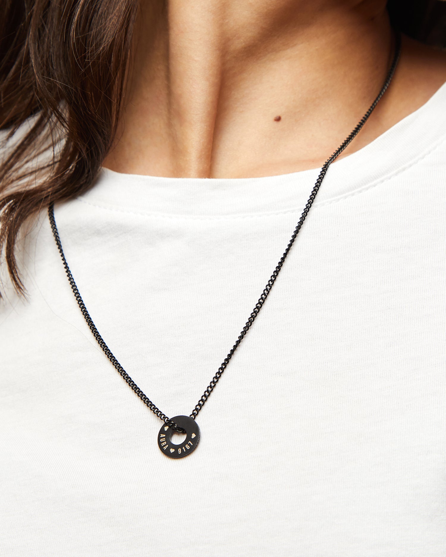 Anilla® negra y cadena Botany sobre una camiseta blanca