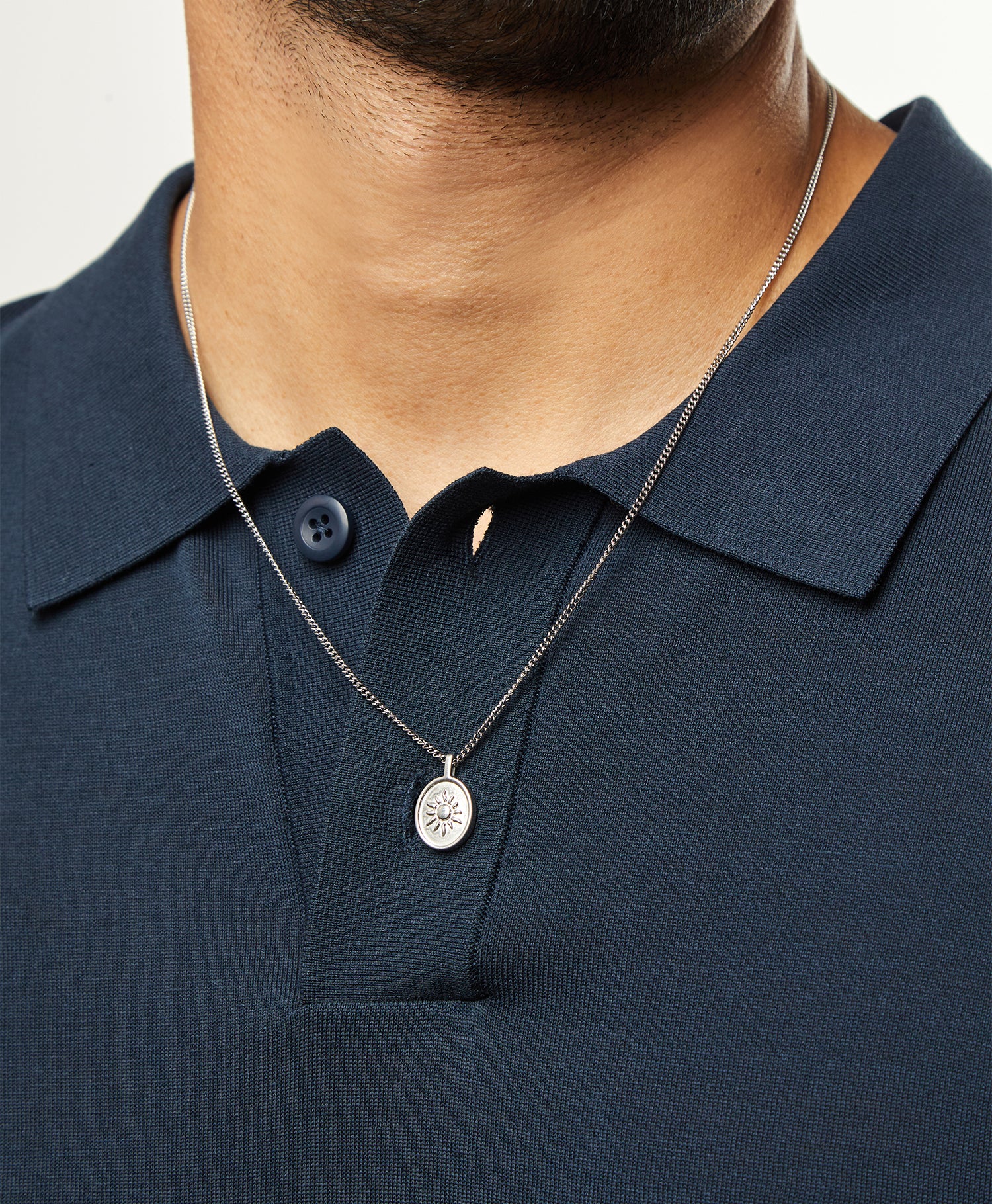 Collar Sentinel® en acero sobre un polo azul marino