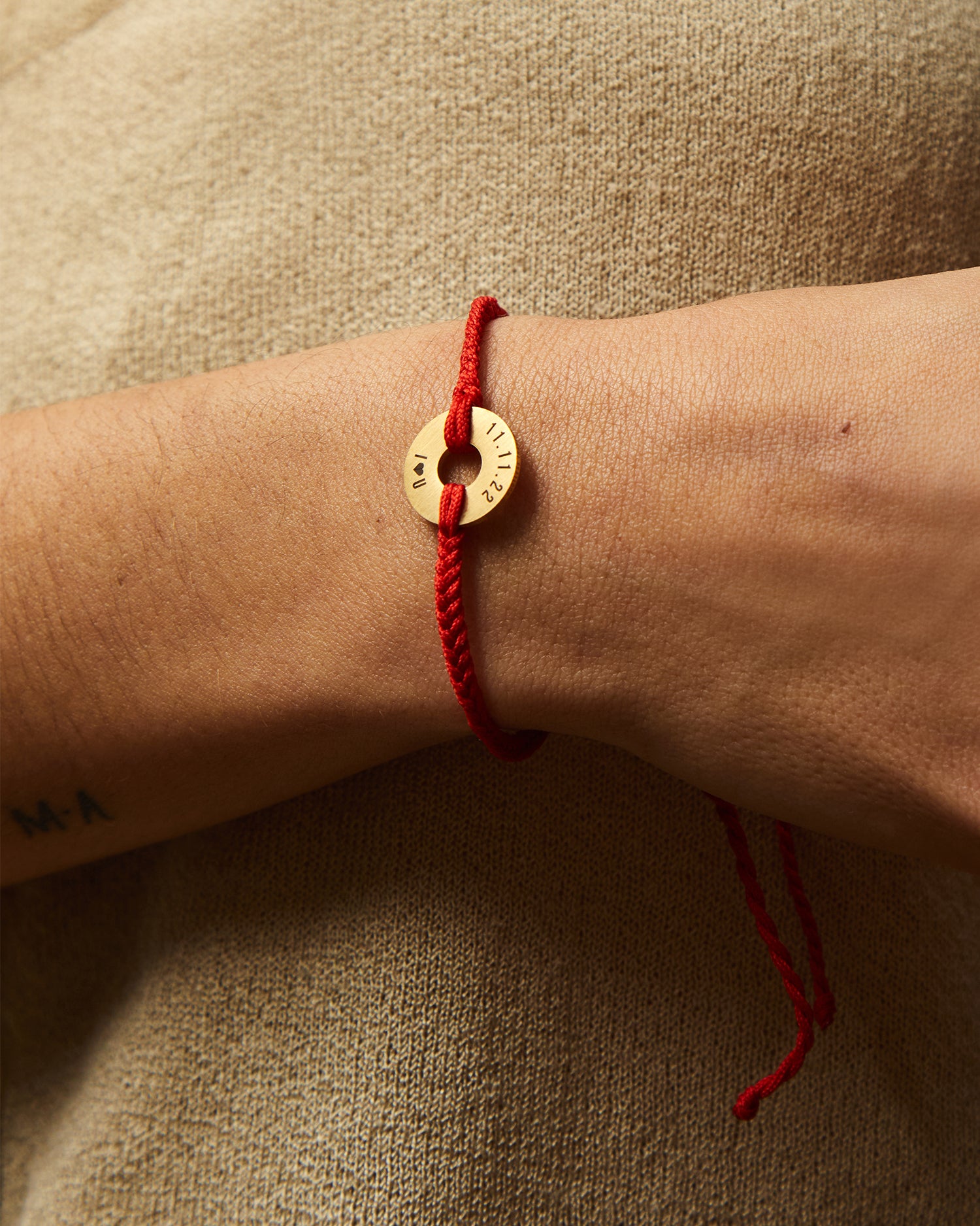 Pulsera MyWord® roja en la muñeca, con el cordón ajustable colgando