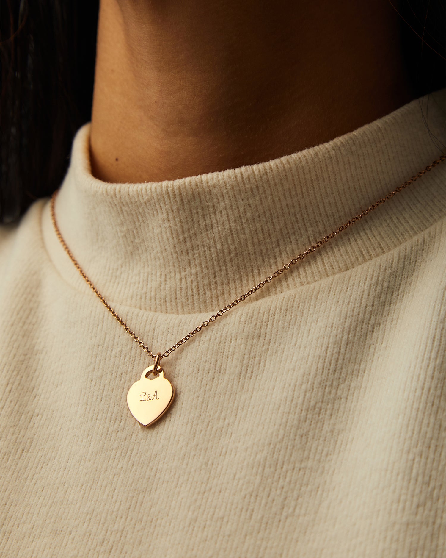 Collar Evora dorado con Colgante Corazón® sobre un jersey de cuello alto