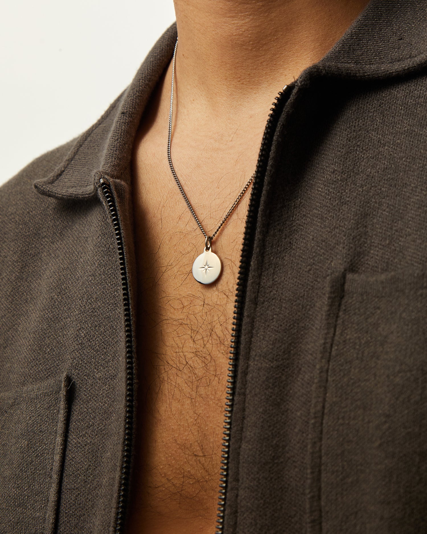 Collar Namib® en acero llevado con una chaqueta marrón abierta