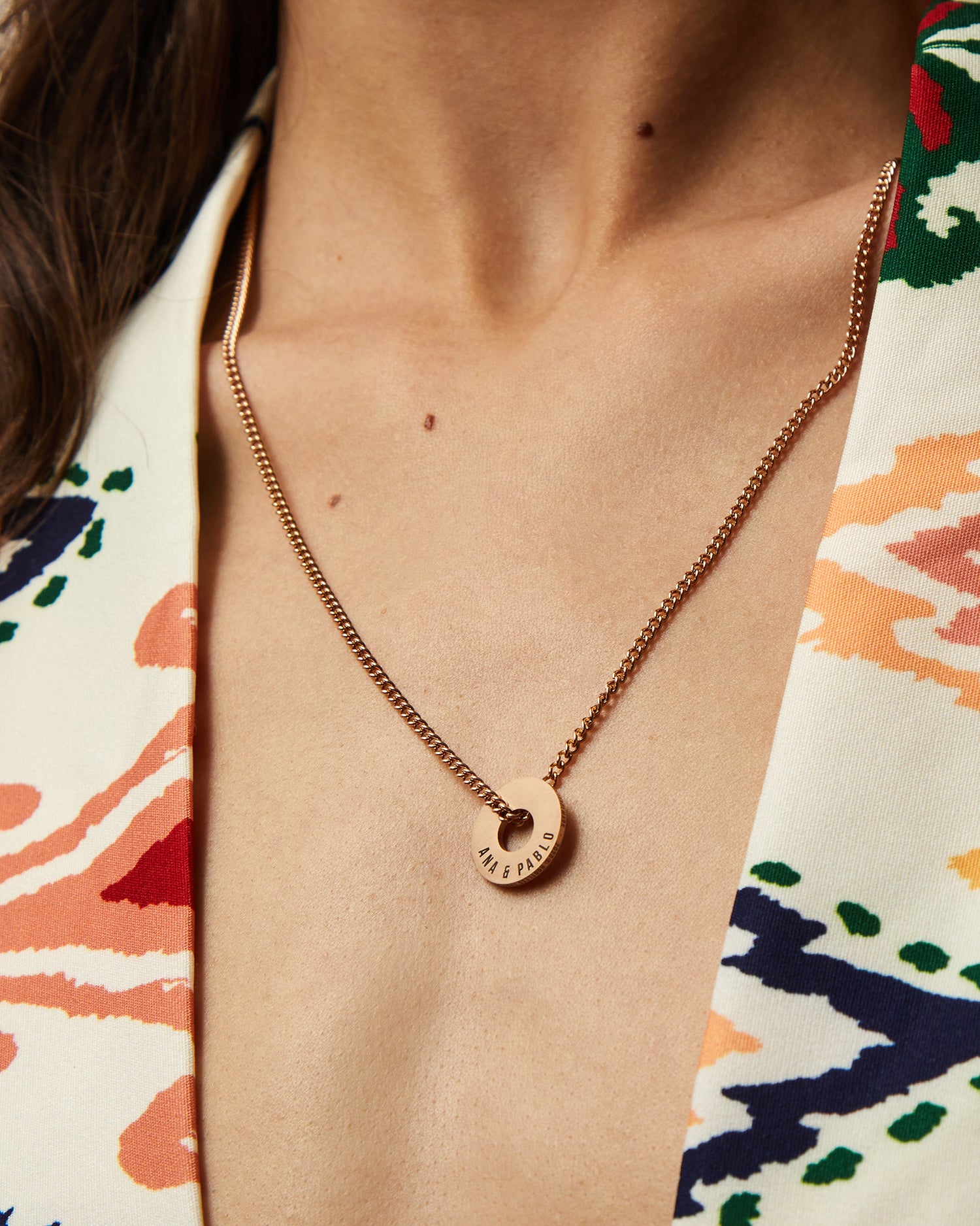 Collar Botany en oro rosa con Anilla® grabada sobre una blusa estampada