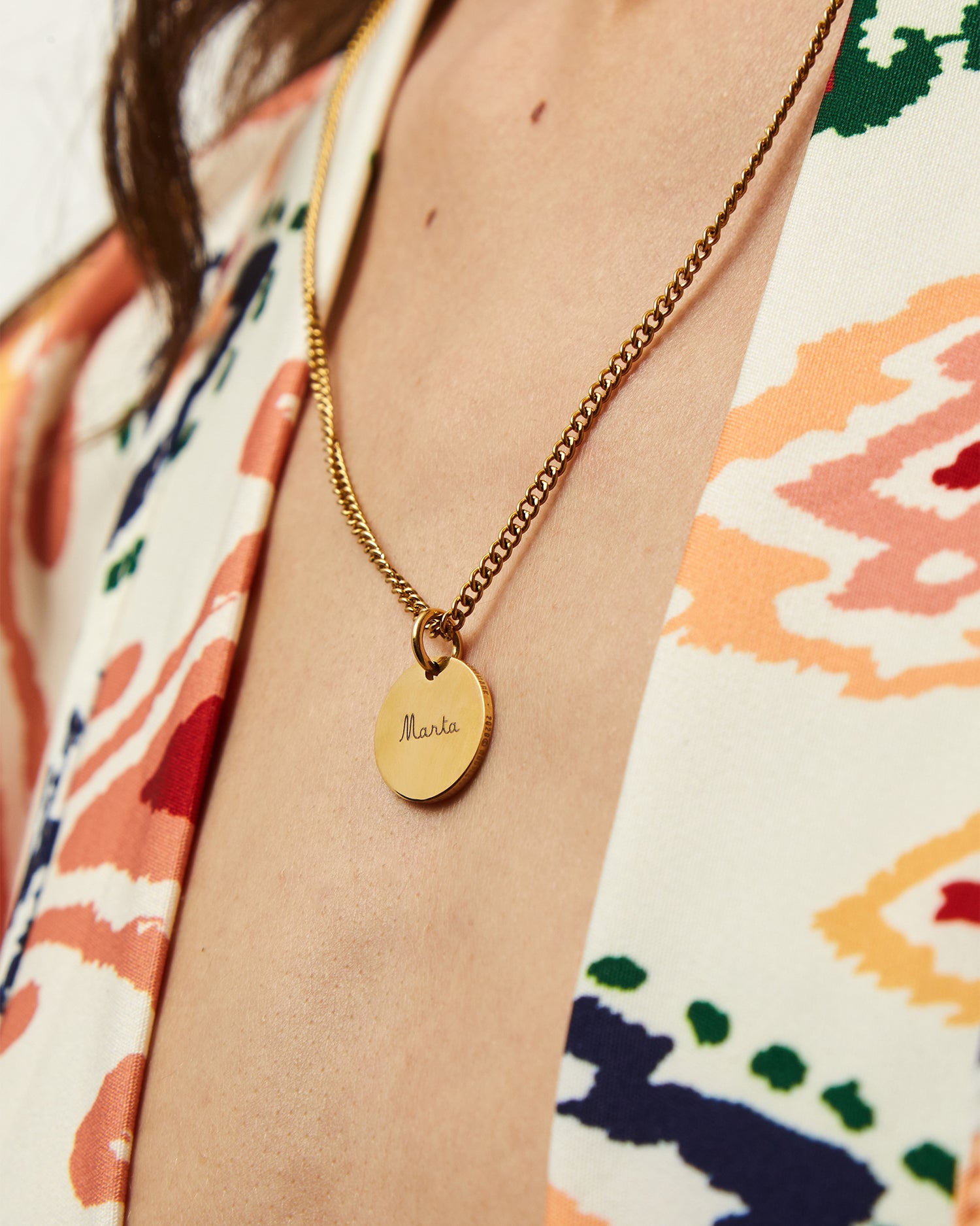 Collar Botany dorado con Colgante Circle® grabado sobre una blusa estampada