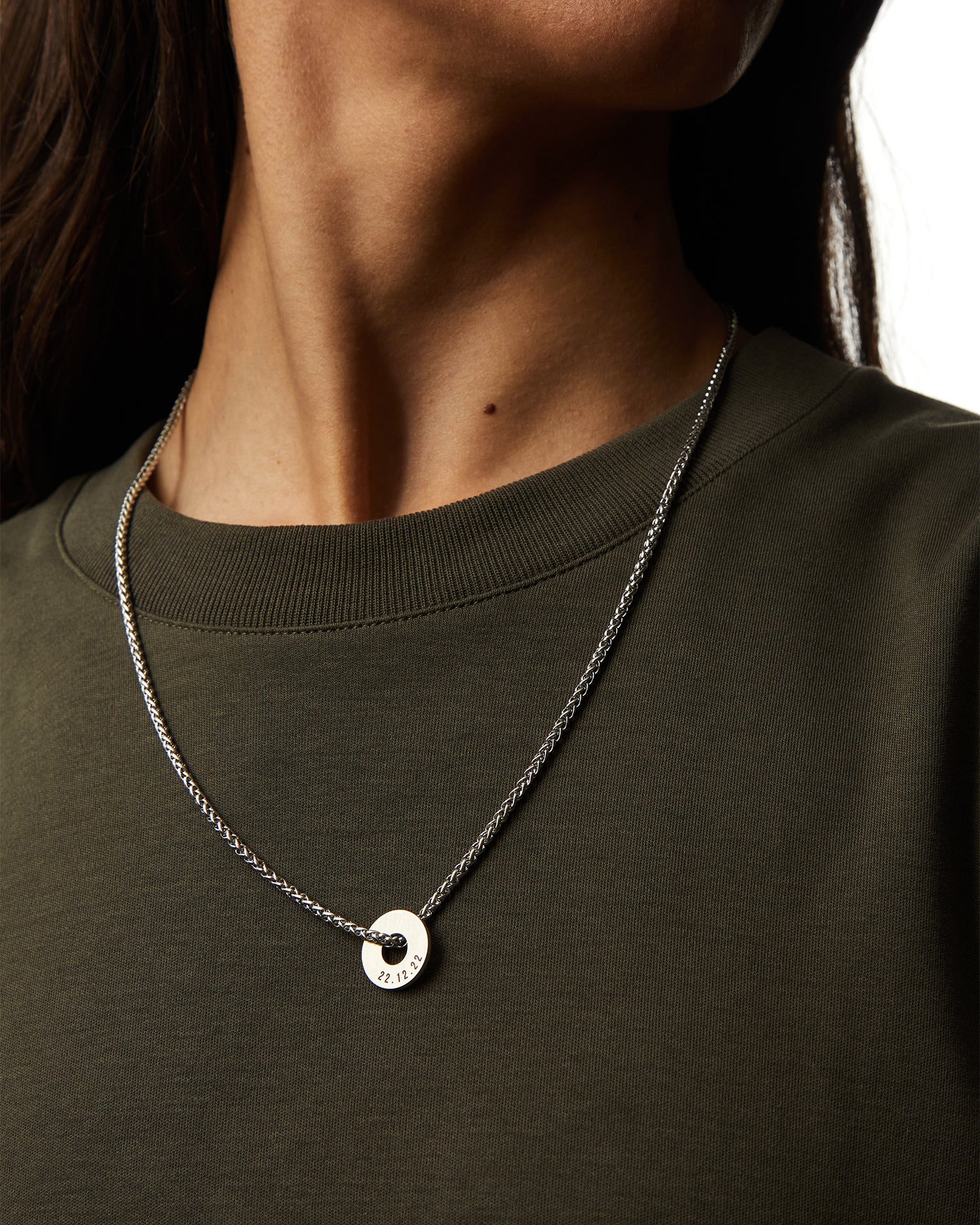Collar Native en acero con Anilla® personalizable sobre una camiseta verde