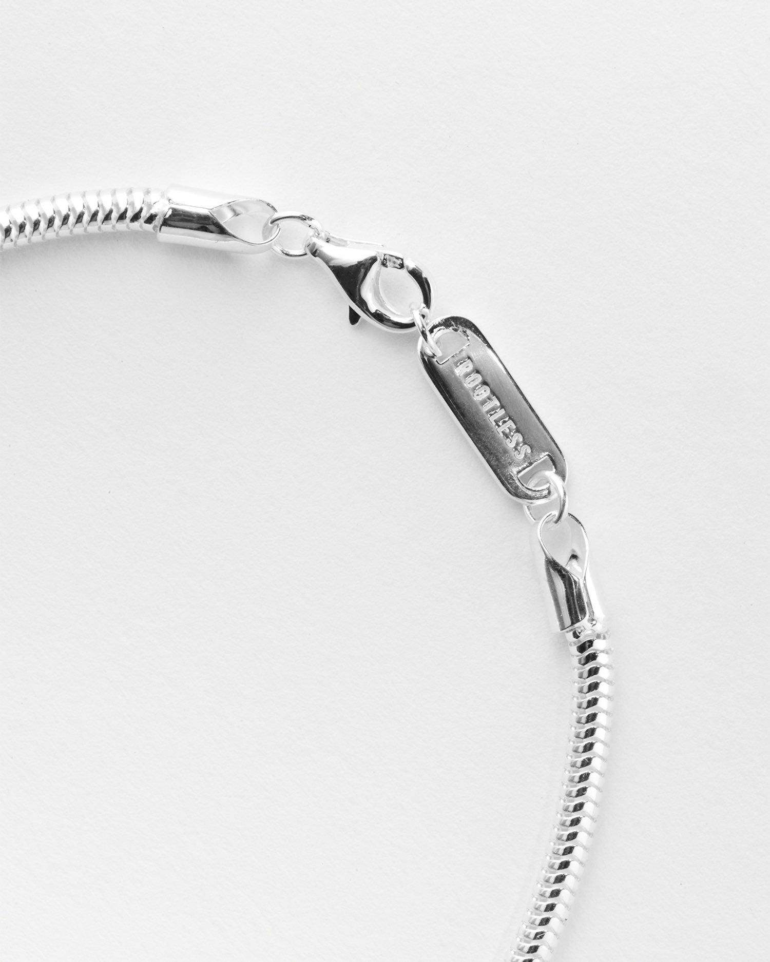 Detalle del cierre de mosquetón y la chapa grabada de la pulsera Royal Boa®