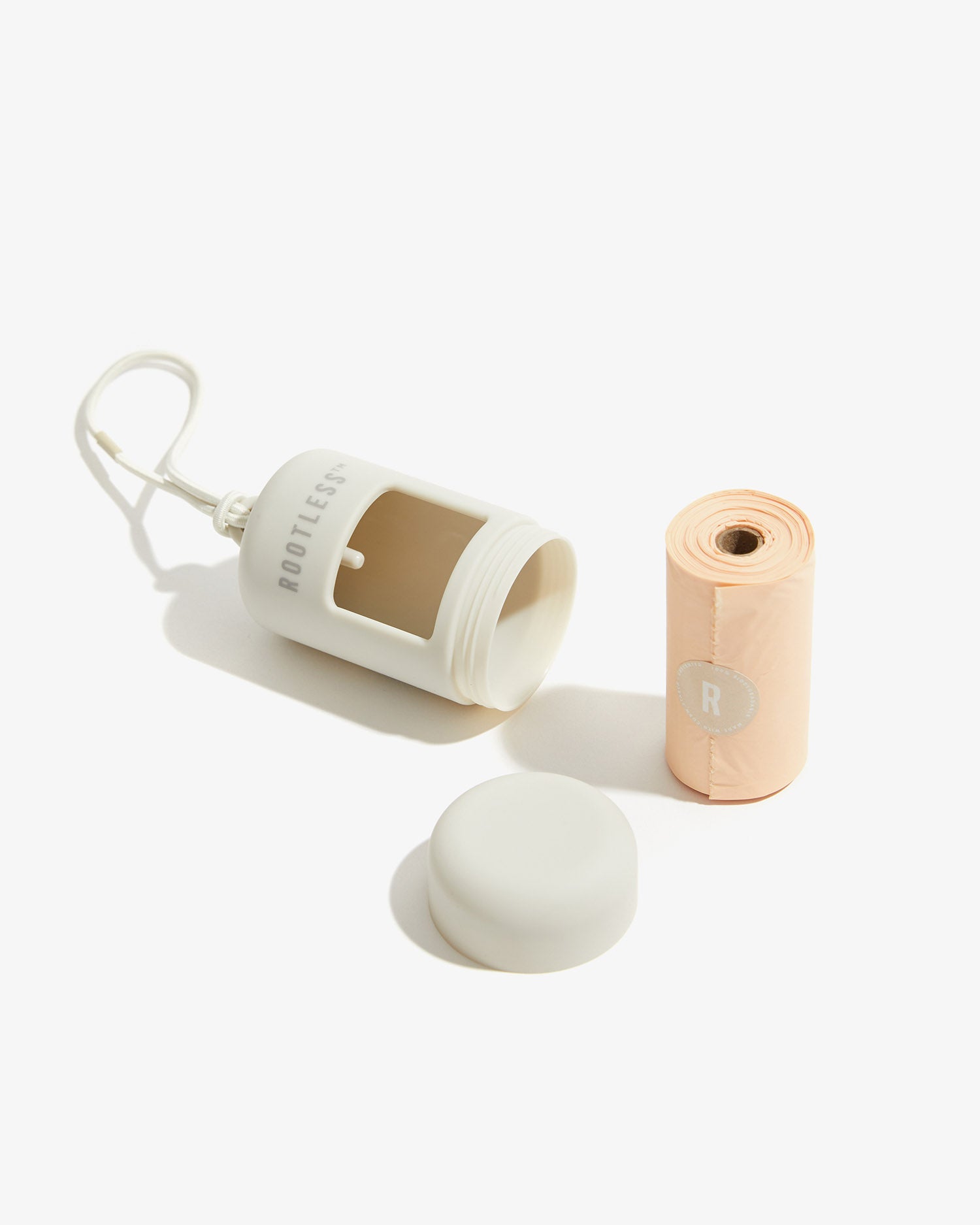 Portabolsas EasyFlex™ stone abierto junto a su tapa giratoria y el rollo de bolsas