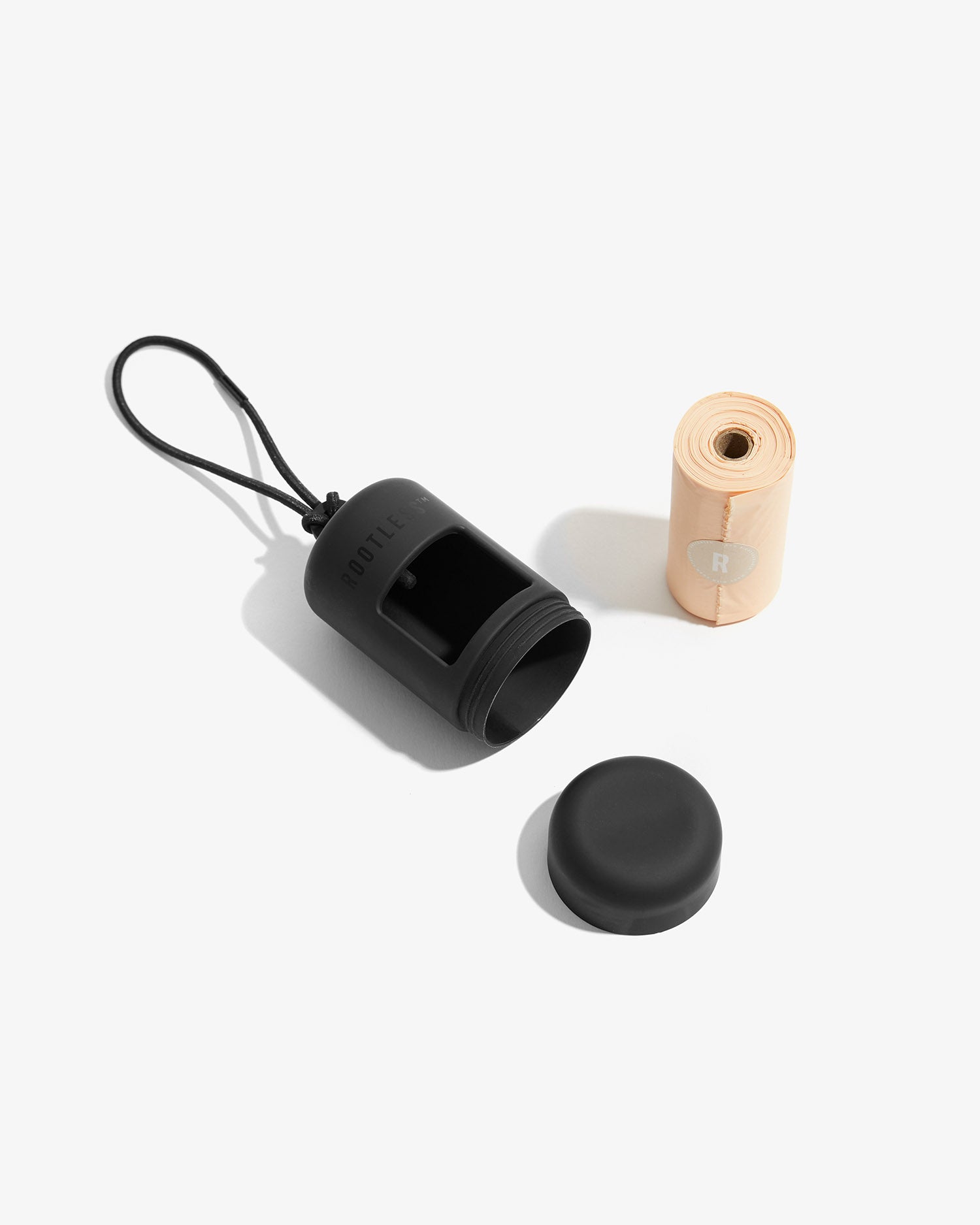 Portabolsas EasyFlex™ negro abierto junto a su tapa y el rollo de bolsas