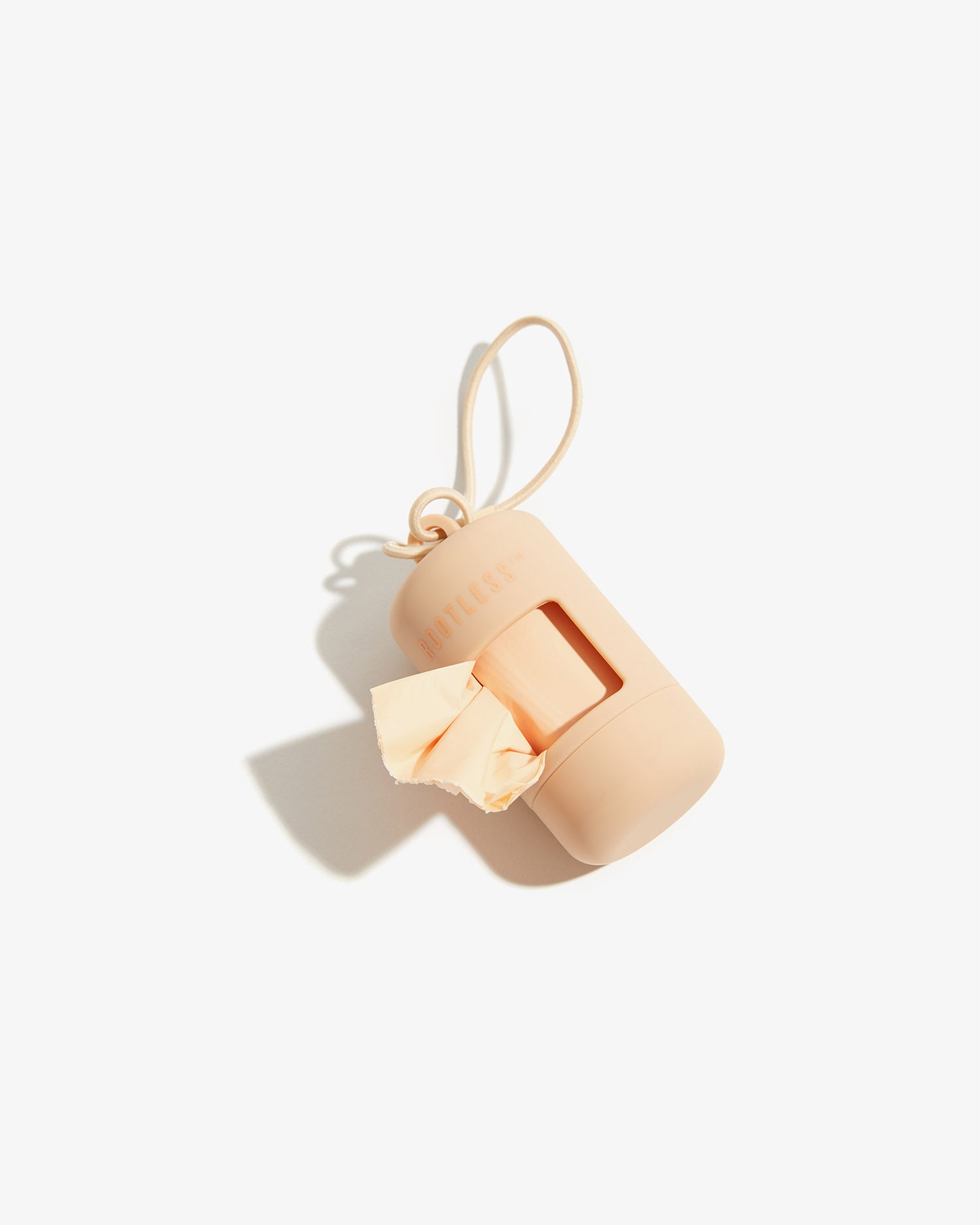 Portabolsas EasyFlex™ nude tumbado con una bolsa asomando