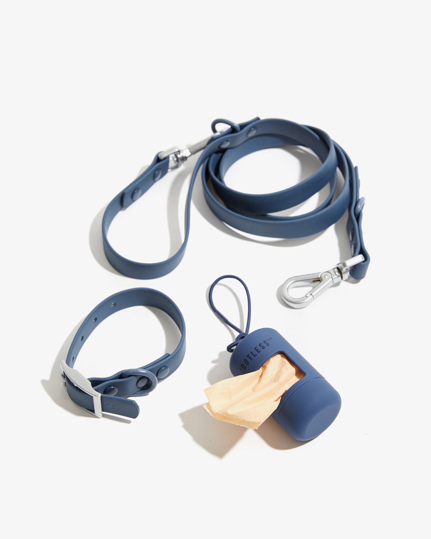 Collar, correa con mosquetón y portabolsas EasyFlex™ azules ordenados sobre fondo claro