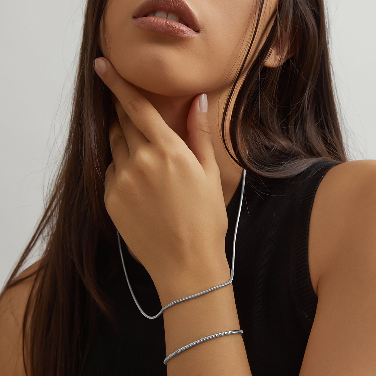 Collar y pulsera Boa® en acero combinados sobre un top negro